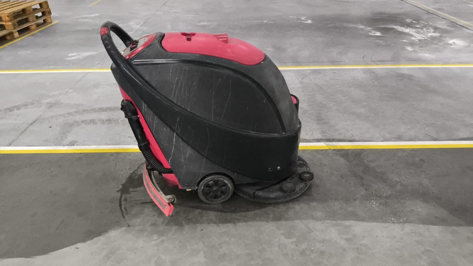 Lavadora automática em operação sobre piso industrial.